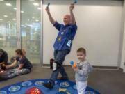 Senior Library Assistant Steve Williams, left, and Matteo Cojocaru, 2, lead the Baby Storytime group in song and dance at the Cascade Park Community Library on Thursday afternoon. The library soon will close for three weeks for minor remodeling.