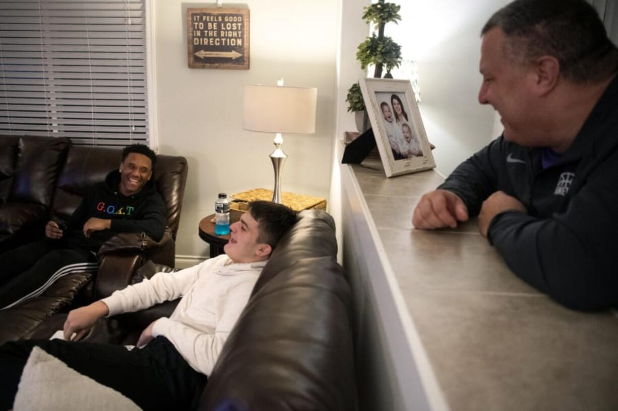 Capone Johnson, left, Conner Childs, center, both 17, and Conner&#039;s dad Brian, right, burst into laughter as they chat after basketball practice together at their home Wednesday in Vancouver.