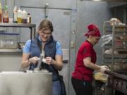 Clark County Public Health Environmental Health Specialist Maggie Yaddof, left, makes a few notes during her inspection of the kitchen at the Fargher Lakehouse.