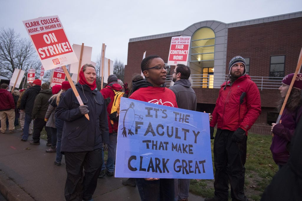 Christina Smith, who is an English professor, with blue sign, joins colleagues while striking at Clark College on Monday morning, Jan. 13, 2020.