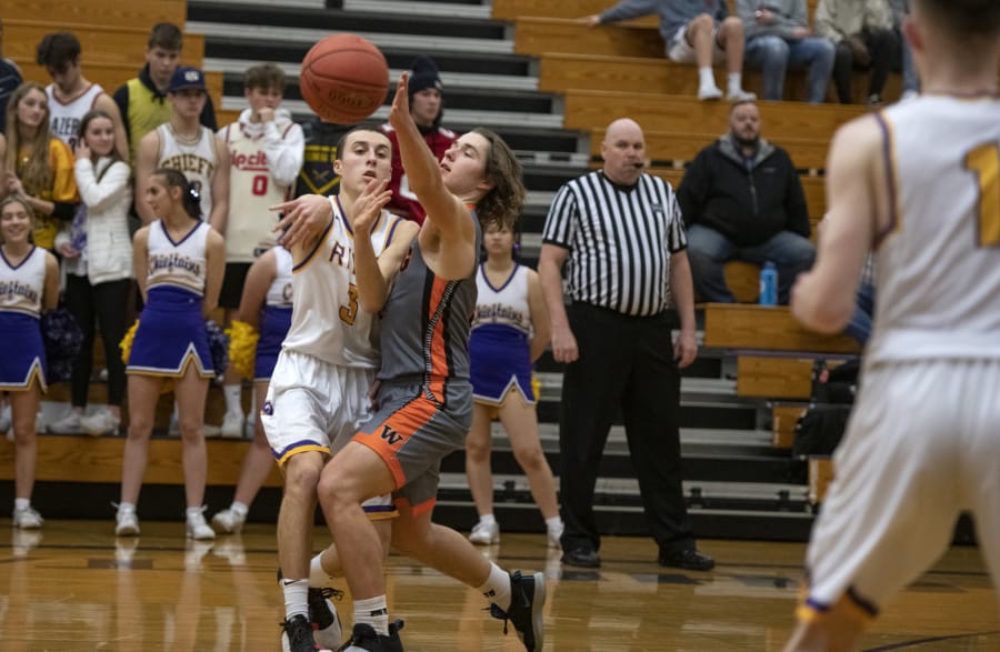 Washougalis Julien Jones (3) defends a pass from Columbia Riveris Alex Miller (3) at Columbia River High School on Friday night, Jan. 17, 2020.