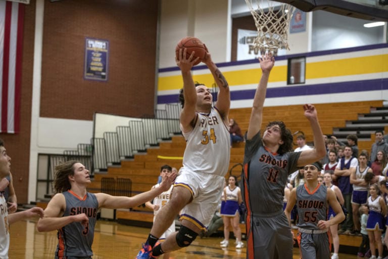 Columbia Riveris Dylan Valdez (34) drives the basket against Washougalis Gabe Kent (11) at Columbia River High School on Friday night, Jan. 17, 2020.