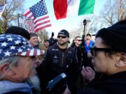 Patriot Prayer leader Joey Gibson, center, leads a protest in Portland in December 2017, a week after an undocumented Mexican resident of San Francisco was acquitted of the murder of Kate Seinle. It drew activists from both political extremes, including Kerry Hudson, left, who can be found at many Patriot Prayer rallies and Luis Enrique Marquez, right, a prominent anti-fascist protester.