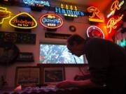 Dave Spencer folds glass tubing into lettering for a neon sign. He plans on working for a new owner as long as the business remains local.