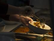 An employee of The Mighty Bowl prepares an order for a customer in downtown Vancouver.