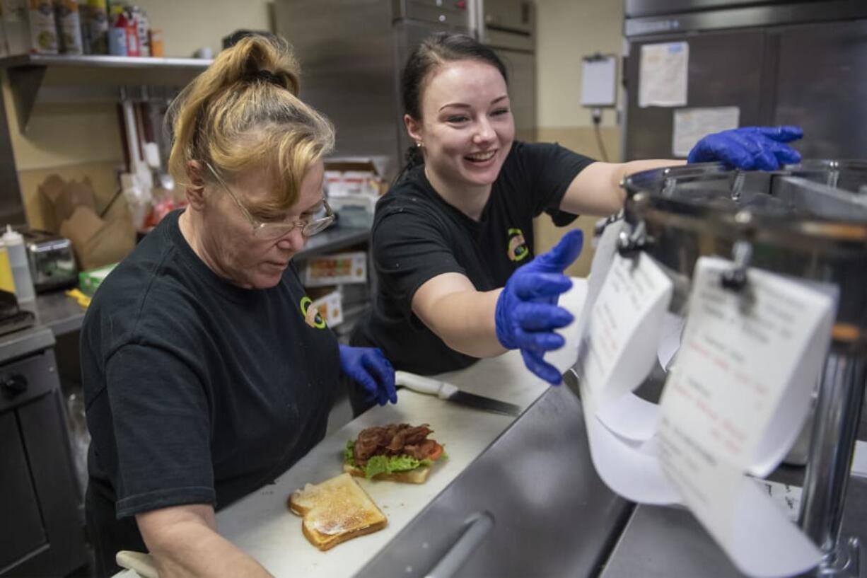 Diana Garner, left, and Ruby Deal complete orders during the lunch rush at Connections Cafe and Catering on the Center for Community Health campus in Vancouver on Wednesday afternoon. Neither had experience working in a restaurant prior to being employed by Lifeline. &quot;I was terrified to start cooking,&quot; Deal said.