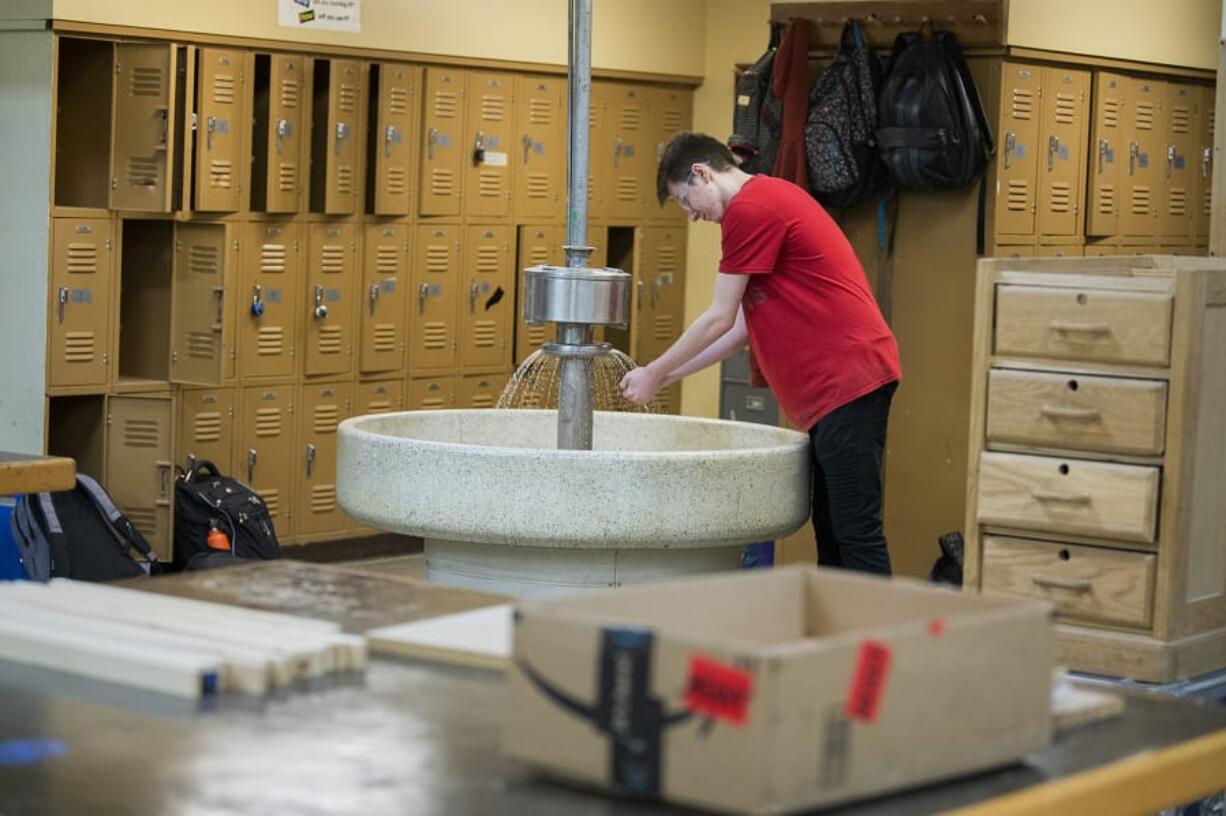 Ridgefield High School senior Jacob Scouller, 18, washes his hands in a sink from another era while joining classmates during wood class Thursday afternoon. The aging wood shop would be among the facilities impacted with the passing of the new bond, as the district eyes construction of a new vocational building.