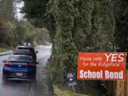 Motorists traveling on South Hillhurst Road pass a sign advertising the upcoming Ridgefield school bond Thursday afternoon. The district is asking voters to approve a $107 million bond that would build new schools and improve existing campuses.