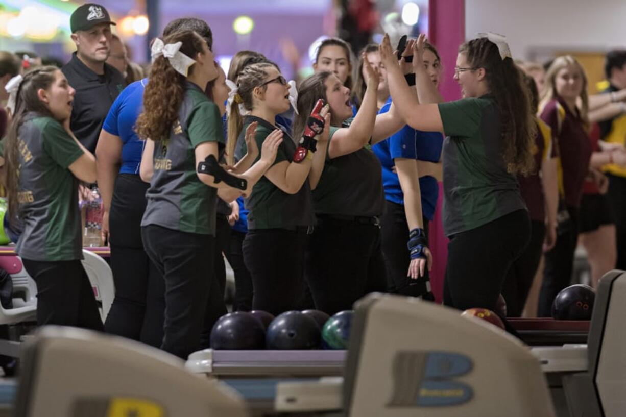 Members of the Evergreen High School girls bowling team celebrate after a shot during district bowling action at Crosley Lanes on Friday afternoon, Jan. 31, 2020.