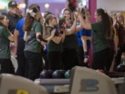 Members of the Evergreen High School girls bowling team celebrate after a shot during district bowling action at Crosley Lanes on Friday afternoon, Jan. 31, 2020.