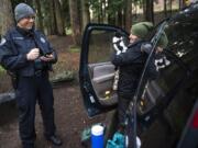 Tyler Chavers, Vancouver&#039;s Homeless Assistance Response Team officer, left, talks with Karalee Grunwald and her cat, Chyzeball, during the 2020 Point in Time count in Vancouver&#039;s Leverich Park. Grunwald said she&#039;s been homeless since June and was recently cited for unlawful camping.