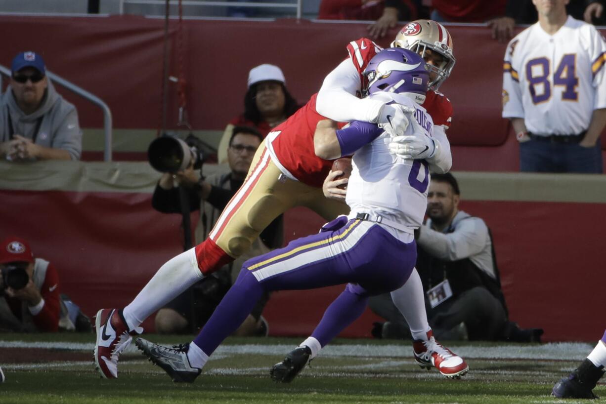 Minnesota Vikings quarterback Kirk Cousins, right, is sacked by San Francisco 49ers defensive end Arik Armstead during the first half of an NFL divisional playoff football game, Saturday, Jan. 11, 2020, in Santa Clara, Calif.