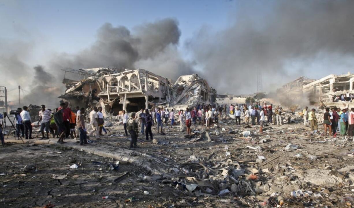 FILE - In this Saturday, Oct. 14, 2017 file photo, Somalis gather and search for survivors by destroyed buildings at the scene of a blast in the capital Mogadishu, Somalia. The U.S. Africa Command, signaling concern over the Pentagon&#039;s potential cuts in a briefing, has emphasized the Somalia-based al-Shabab as a threat to the U.S.