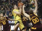 Oregon&#039;s Payton Pritchard, center, is fouled while going to the basket between Arizona State&#039;s Jaelen House, left, and Mickey Mitchell, right, during the second half of an NCAA college basketball game in Eugene, Ore., Saturday, Jan. 11, 2020.