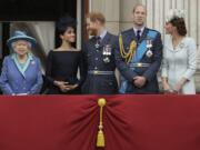 Britain&#039;s Queen Elizabeth II, and from left, Meghan the Duchess of Sussex, Prince Harry, Prince William and Kate the Duchess of Cambridge watch July 10, 2018, a flypast of Royal Air Force aircraft pass over Buckingham Palace in London.