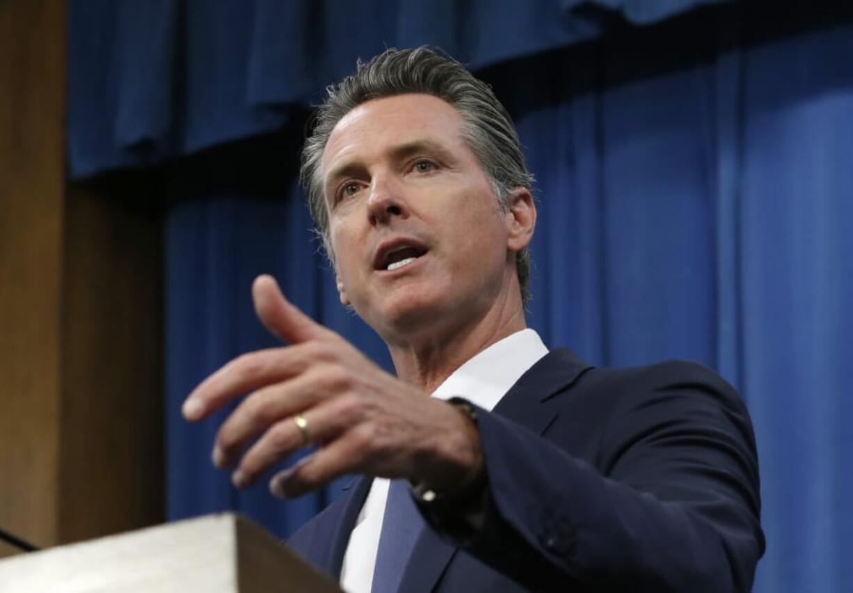 FILE - In this July 23, 2019, file photo, Gov. Gavin Newsom talks to reporters at his Capitol office, in Sacramento, Calif. California could become the first state with its own prescription drug label. Newsom announced Thursday, Jan. 9, 2020, he wants California to contract with generic drug companies to make prescription medications on behalf of the state so it can sell them to the public. He said the goal is to lower prices by increasing competition in the generic market. State lawmakers must approve the plan before it can take effect.