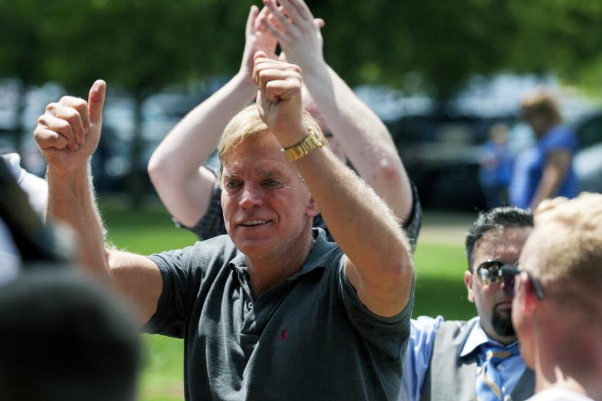 FILE - In an Aug. 12, 2017, file photo, David Duke arrives to give remarks after a white nationalist protest was declared an unlawful assembly, in Charlottesville, Va. Duke, a former Ku Klux Klan leader, has agreed to pay Bill Burke, of Athens, Ohio, $5,000 to settle allegations that Burke was severely injured during a white supremacist and neo-Nazi rally two years ago in Virginia attended by Duke, according to attorneys and court documents.