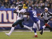 Philadelphia Eagles quarterback Carson Wentz (11) runs with the ball past New York Giants defensive back Michael Thomas (31) in the first half of an NFL football game, Sunday, Dec. 29, 2019, in East Rutherford, N.J.