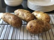 Four baked potatoes rest on a rack in Amagansett, N.Y.