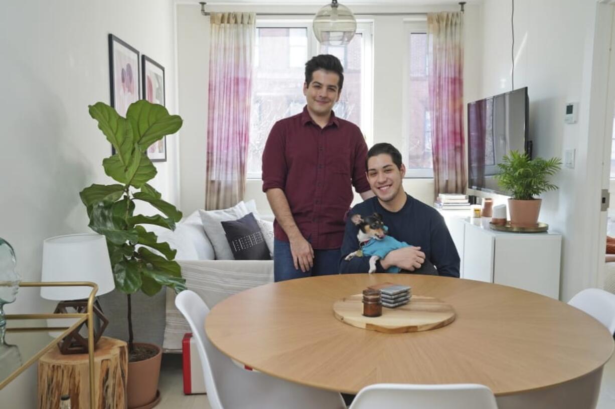 Most of the furniture in the of apartment of Zachariah Mohammed, left, and Pete Mancilla, with their dog Remy, including the couch, the table and chairs, the side table and the bar cart, are rented.