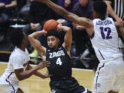 Portland guard Quincy Ferebee, left, and center Theo Akwuba, right, defend against Gonzaga guard Ryan Woolridge, center, during the first half of an NCAA college basketball game in Portland, Ore., Thursday, Jan. 2, 2020.