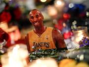 A picture of the late Kobe Bryant is displayed at a memorial near Staples Center, Tuesday, Jan. 28, 2020, in Los Angeles. Bryant, the 18-time NBA All-Star who won five championships and became one of the greatest basketball players of his generation during a 20-year career with the Los Angeles Lakers, died in a helicopter crash Sunday. (AP Photo/Ringo H.W.