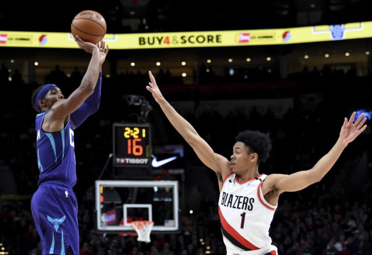 Charlotte Hornets guard Devonte&#039; Graham, left, shoots the ball over Portland Trail Blazers guard Anfernee Simons, right, during the first half of an NBA basketball game in Portland, Ore., Monday, Jan. 13, 2020.