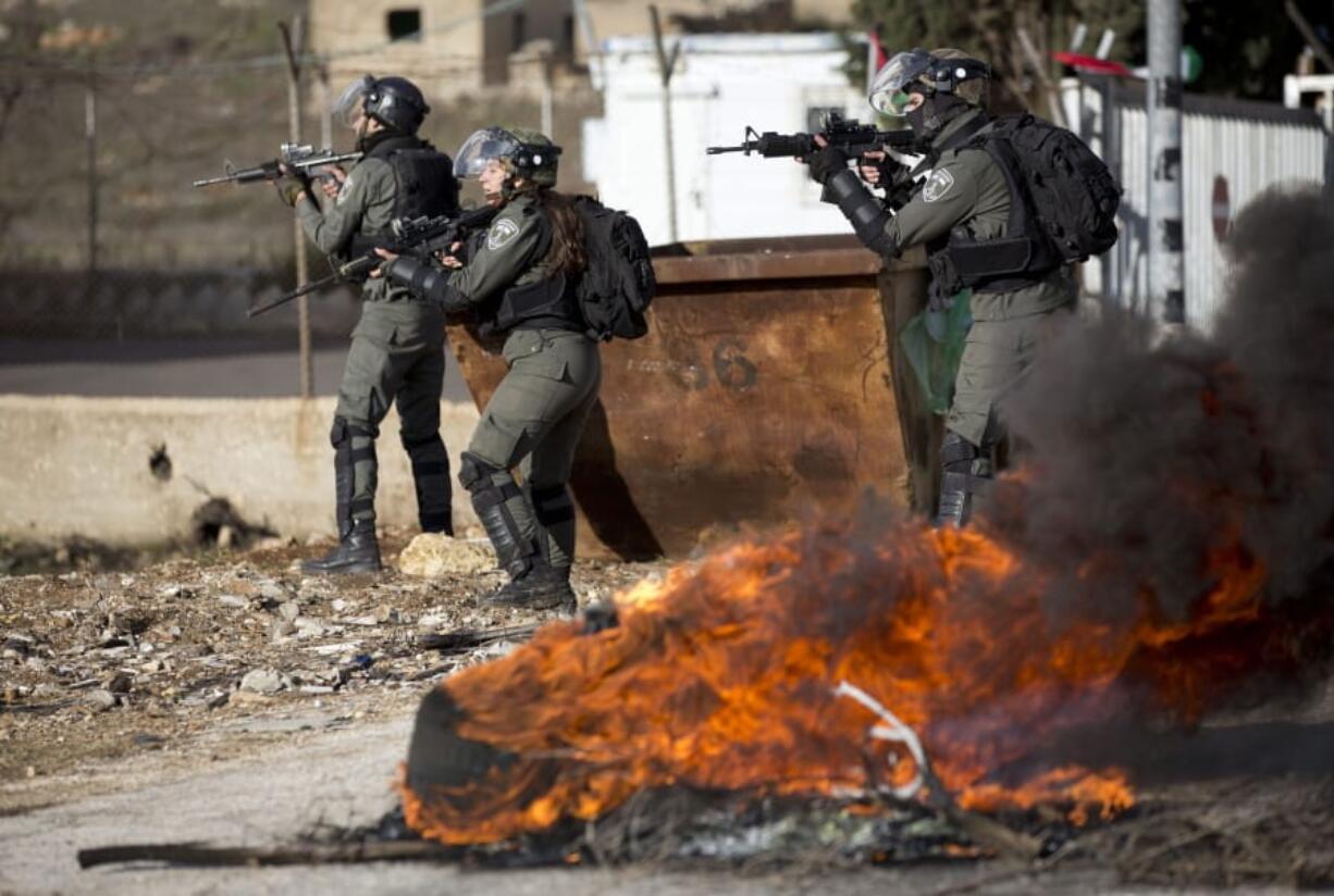 Israeli troops take their position during clashes with Palestinian demonstrators as they protest Middle East peace plan announced Tuesday by US President Donald Trump, which strongly favors Israel, at Beit El checkpoint, near the West Bank city of Ramallah, Wednesday, Jan 29, 2020 (AP Photo/Majdi Mohammed)