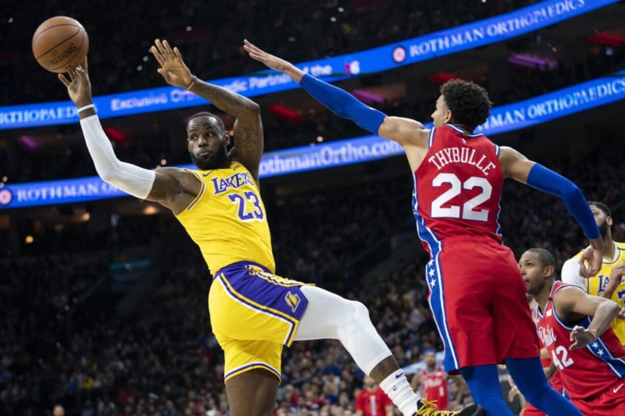 Los Angeles Lakers&#039; LeBron James, right, puts up the ball with Philadelphia 76ers&#039; Shake Milton, left, defending during the second half of an NBA basketball game, Saturday, Jan. 25, 2020, in Philadelphia. LeBron James passes Kobe Bryant for third on the NBA all-time scoring.