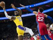 Los Angeles Lakers&#039; LeBron James, right, puts up the ball with Philadelphia 76ers&#039; Shake Milton, left, defending during the second half of an NBA basketball game, Saturday, Jan. 25, 2020, in Philadelphia. LeBron James passes Kobe Bryant for third on the NBA all-time scoring.