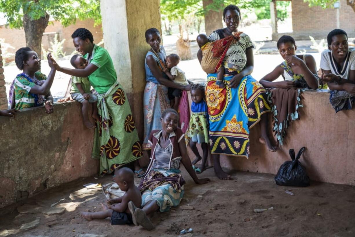 In this photo taken Wednesday, Dec. 11, 2019, residents of the Malawi village of Tomali wait to have their young children become test subjects for the world&#039;s first vaccine against malaria. Babies in three African nations are getting the first and only vaccine for malaria in a pilot program.