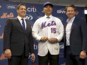 FILE - In this Nov. 4, 2019, file photo, new New York Mets manager, Carlos Beltran, center, poses for a picture with general manager Brodie Van Wagenen, left, and Mets COO Jeff Wilpon during a baseball news conference at Citi Field in New York. Beltran is out as manager of the Mets. The team announced the move Thursday, Jan. 16, 2020.