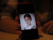 In this Jan. 14, 2020 photo, Ana Lucia Salazar shows a photo of herself when she was 8-years-old, on her smart phone during an interview with the Associated Press in Mexico City. At the time Salazar says she was sexually abused by a Legion of Christ priest.