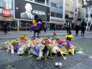 Flowers and candles are placed at a memorial for Kobe Bryant near Staples Center Monday, Jan. 27, 2020, in Los Angeles. Bryant, the 18-time NBA All-Star who won five championships and became one of the greatest basketball players of his generation during a 20-year career with the Los Angeles Lakers, died in a helicopter crash Sunday. (AP Photo/Ringo H.W.