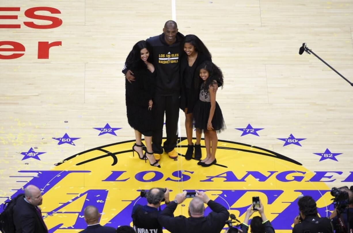 FILE - In this April 13, 2016, file photo, Los Angeles Lakers&#039; Kobe Bryant poses for pictures with his wife Vanessa, left, and daughters Natalia, second from right, and Gianna as they stand on the court after an NBA basketball game against the Utah Jazz, in Los Angeles. Bryant, the 18-time NBA All-Star who won five championships and became one of the greatest basketball players of his generation during a 20-year career with the Los Angeles Lakers, died in a helicopter crash Sunday, Jan. 26, 2020.(AP Photo/Mark J.