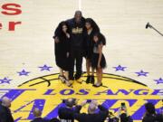 FILE - In this April 13, 2016, file photo, Los Angeles Lakers&#039; Kobe Bryant poses for pictures with his wife Vanessa, left, and daughters Natalia, second from right, and Gianna as they stand on the court after an NBA basketball game against the Utah Jazz, in Los Angeles. Bryant, the 18-time NBA All-Star who won five championships and became one of the greatest basketball players of his generation during a 20-year career with the Los Angeles Lakers, died in a helicopter crash Sunday, Jan. 26, 2020.(AP Photo/Mark J.