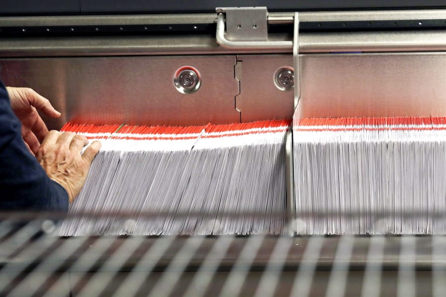 An election worker stacks ballots into a sorting machine Nov. 7, 2018, at the King County Elections office in Renton. An obscure Seattle-area election will be the first in the country where all voters will be allowed to vote online.