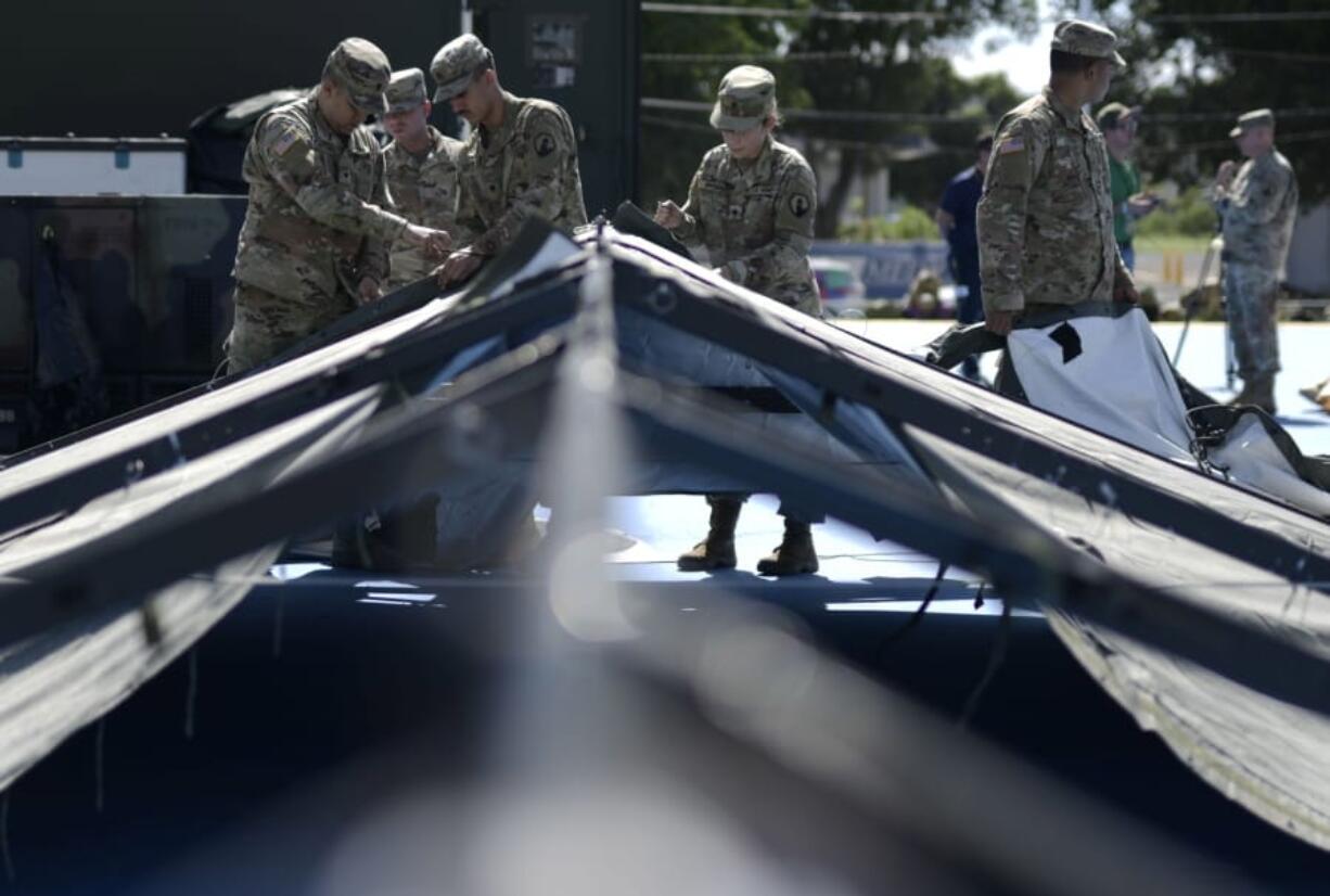 Members of the US army reserve set up tents for portable showers at a tent city set up to house hundreds of people displaced by earthquakes in Guanica, Puerto Rico, Tuesday, Jan. 14, 2020. More than 1,280 earthquakes have hit Puerto Rico&#039;s southern region since Dec. 28, more than two dozen of them magnitude 4.5 or greater, according to the U.S. Geological Survey.