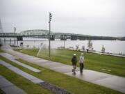 Kim Pohlman of Vancouver, left, Karen Conway of Cincinnati, Ohio, right, and walk along the Vancouver Waterfront Park on Friday afternoon, Oct. 5, 2018. Conway use to live in Vancouver and is back for a visit so the friends decided to brave the rain to check it out. "We were smiling because rain doesn't stop us," Pohlman said.