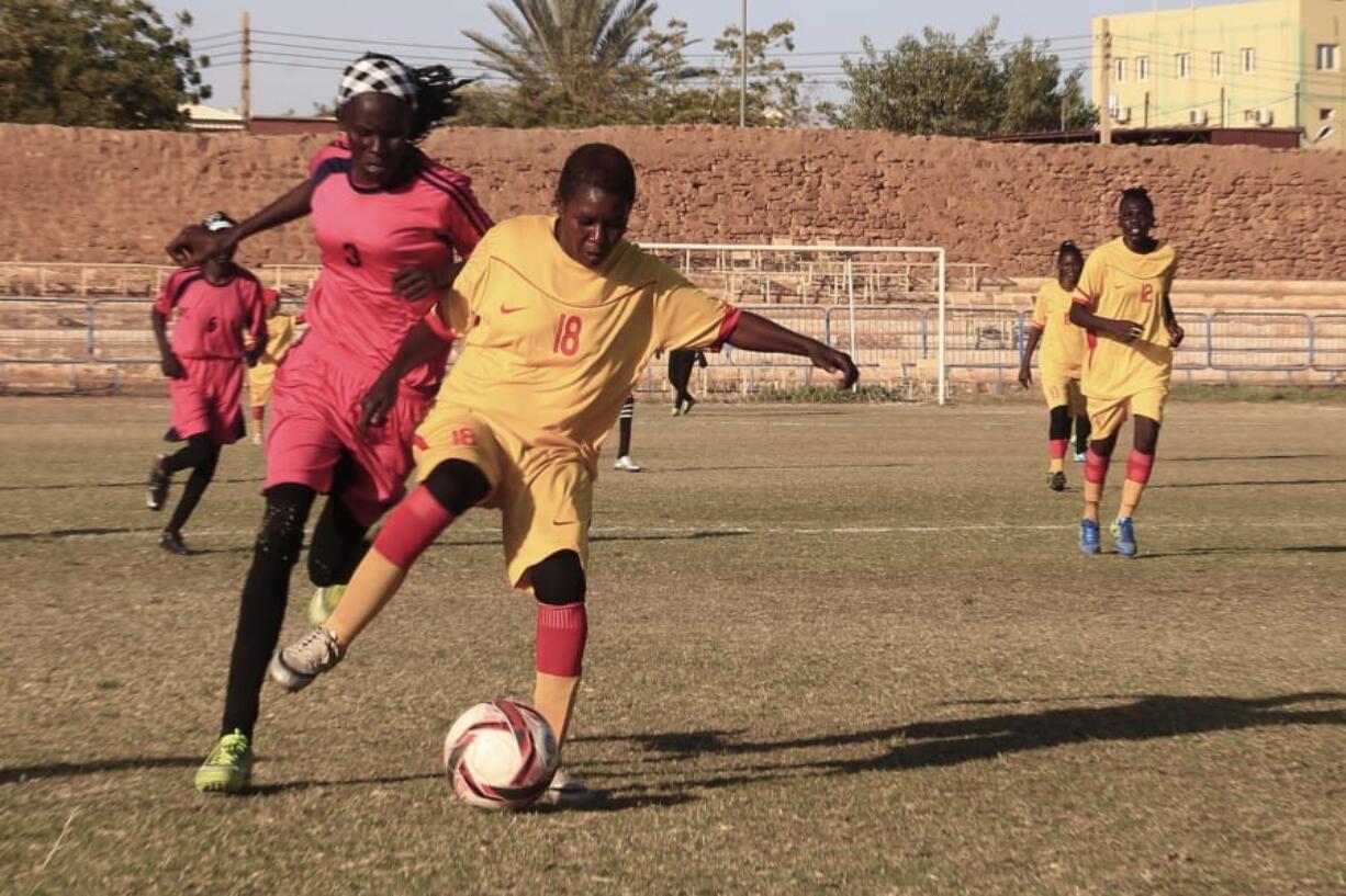 In this Wednesday, Dec. 11, 2019 photo, Sudanese al-Difaa, in yellow, and al-Sumood women teams play in Omdurman, Khartoum&#039;s twin city, Sudan. The women&#039;s soccer league has become a field of contention as Sudan grapples with the transition from three decades of authoritarian rule that espoused a strict interpretation of Islamic Shariah law.