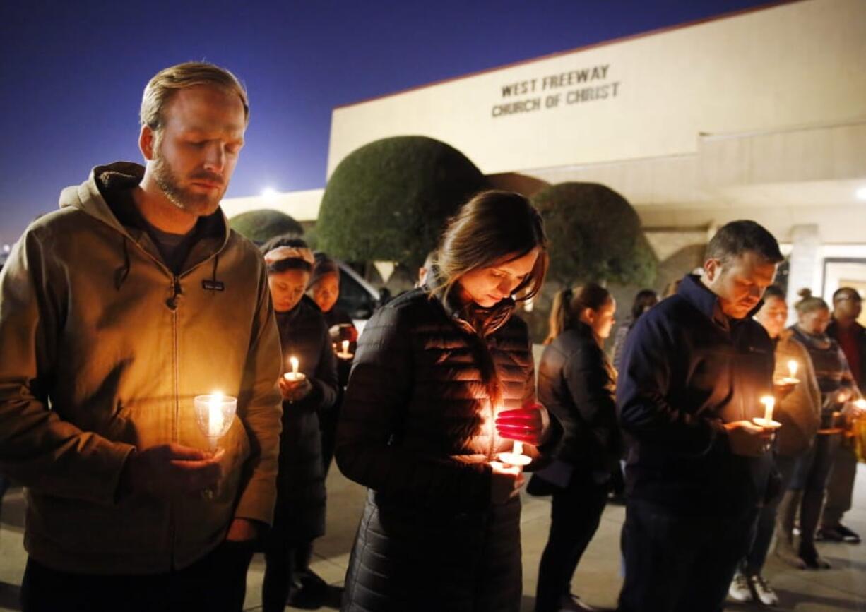 FILE - In this Monday, Dec. 30, 2019, file photo, church and community members, including Matt Pacholczyk, left, and his wife, Faith Pacholczyk, stand outside West Freeway Church of Christ for a candlelight vigil in White Settlement, Texas. The machete attack on a rabbi&#039;s home in Monsey, New York, during Hanukkah and the shooting of worshippers at a Texas church are refocusing attention on how vulnerable worshippers are during religious services. FBI hate crime statistics show there is reason for concern.