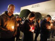 FILE - In this Monday, Dec. 30, 2019, file photo, church and community members, including Matt Pacholczyk, left, and his wife, Faith Pacholczyk, stand outside West Freeway Church of Christ for a candlelight vigil in White Settlement, Texas. The machete attack on a rabbi&#039;s home in Monsey, New York, during Hanukkah and the shooting of worshippers at a Texas church are refocusing attention on how vulnerable worshippers are during religious services. FBI hate crime statistics show there is reason for concern.