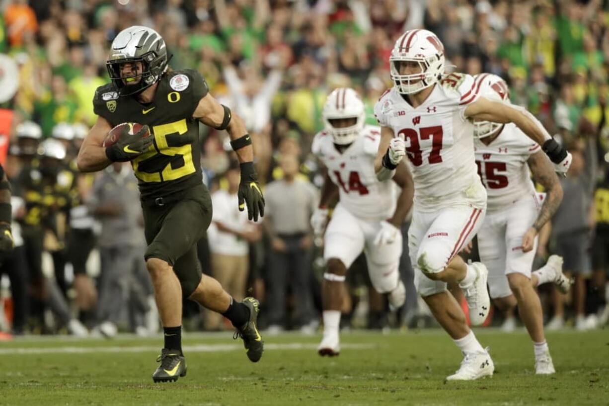 Oregon quarterback Justin Herbert runs for a touchdown past Wisconsin linebacker Jack Sanborn during second half of the Rose Bowl NCAA college football game Wednesday, Jan. 1, 2020, in Pasadena, Calif. (AP Photo/Mark J.