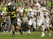 Oregon quarterback Justin Herbert runs for a touchdown past Wisconsin linebacker Jack Sanborn during second half of the Rose Bowl NCAA college football game Wednesday, Jan. 1, 2020, in Pasadena, Calif. (AP Photo/Mark J.