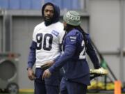 Seattle Seahawks running back Marshawn Lynch, right, stretches as he talks with defensive end Jadeveon Clowney, left, before NFL football practice, Friday, Dec. 27, 2019, in Renton, Wash. (AP Photo/Ted S.