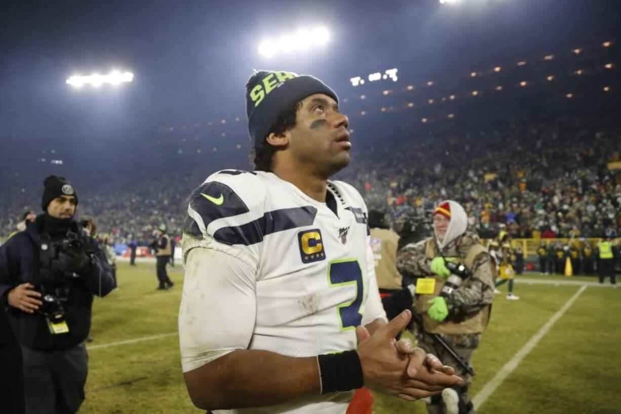 Seattle Seahawks&#039; Russell Wilson walks off the field after a 28-23 loss to the Green Bay Packers in the NFL divisional playoffs on Sunday.