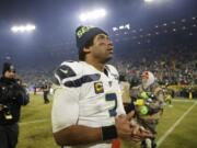 Seattle Seahawks&#039; Russell Wilson walks off the field after a 28-23 loss to the Green Bay Packers in the NFL divisional playoffs on Sunday.