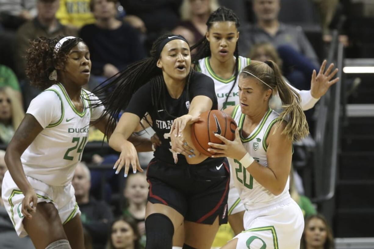 Oregon&#039;s Ruthy Hebard, left, Satou Sabally, rear, and Sabrina Ionescu, right, battle Stanford&#039;s Haley Jones for the ball during Thursday&#039;s game in Eugene, Ore.