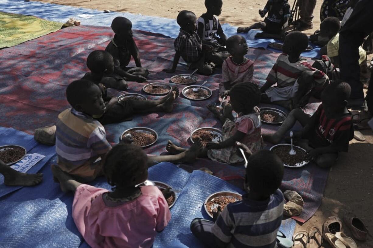 Children eat food distributed during a visit organized by The World Food Program (WFP) at Koge school, in the conflict-affected remote town of Kauda, Nuba Mountains, Sudan, Jan. 9, 2020. Sudanese Prime Minister Abdalla Hamdok, accompanied by United Nations officials, embarked on a peace mission Thursday to Kauda, a rebel stronghold, in a major step toward government efforts to end the country&#039;s long-running civil conflicts.