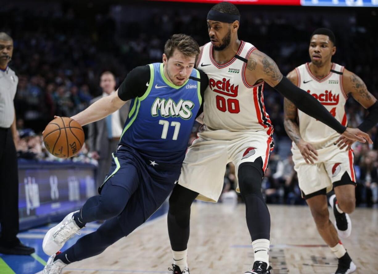 Dallas Mavericks forward Luka Doncic (77) drives on Portland Trail Blazers forward Carmelo Anthony.